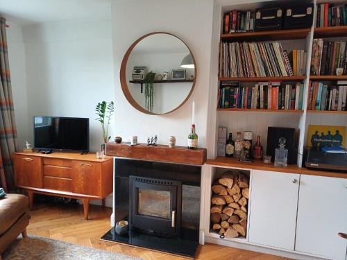 a living room with a fireplace and a mirror at 2 Bedroom Cork City House in Cork