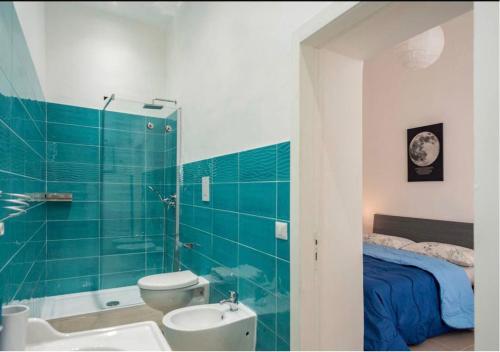 a bathroom with a toilet and a sink and a bed at Spagno li's House in Naples