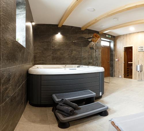 a bathroom with a bath tub and a sink at RHOLL Pension & Restaurant in Hámry
