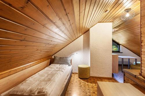 a bed in a room with a wooden ceiling at Azalea in Olsberg