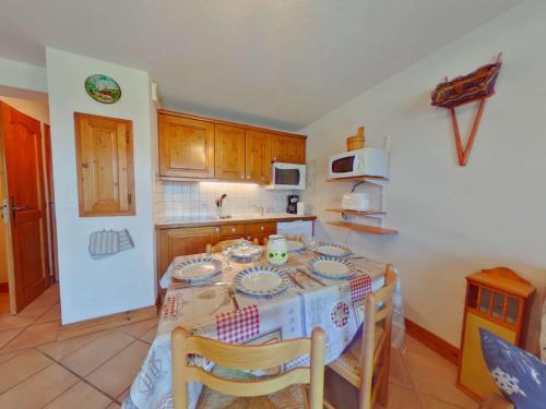 une cuisine avec une table, des chaises et une nappe dans l'établissement Appartement cosy 2 pièces, 6 pers, Les Saisies, balcon, animaux admis - FR-1-594-99, à Hauteluce