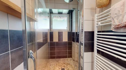 une salle de bain avec une douche avec une porte vitrée dans l'établissement Evasion Nature Rimbach, à Rimbach-près-Masevaux