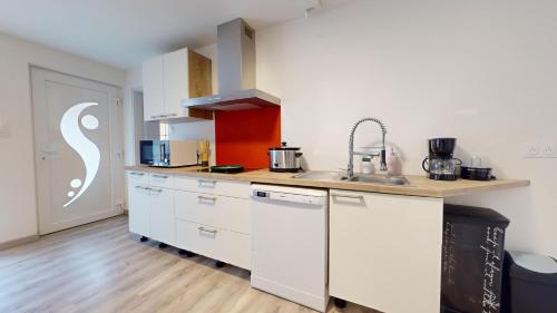 une cuisine avec des armoires blanches et un évier dans l'établissement Evasion Nature Rimbach, à Rimbach-près-Masevaux