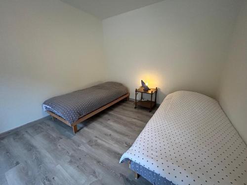 - 2 lits jumeaux dans une chambre avec une table de nuit dans l'établissement Evasion Nature Rimbach, à Rimbach-près-Masevaux