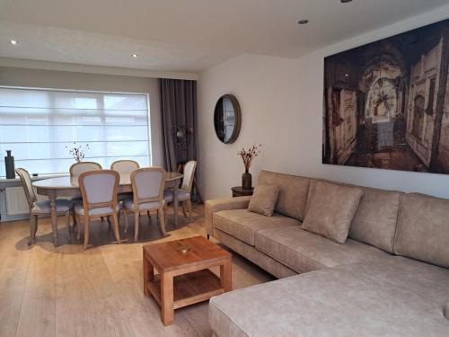 a living room with a couch and a table at Nature Zeeland in Lamswaarde