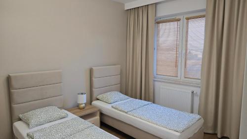 a bedroom with two beds and a window at Apartament Gimnazjalna Luxury in Końskie