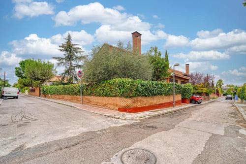 a house with a hedge on the side of a street at P CasaCafe Madrid Calle Carlos Dubois 3 in Madrid