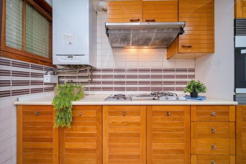 a kitchen with wooden cabinets and a stove top oven at P CasaCafe Madrid Calle Carlos Dubois 3 in Madrid