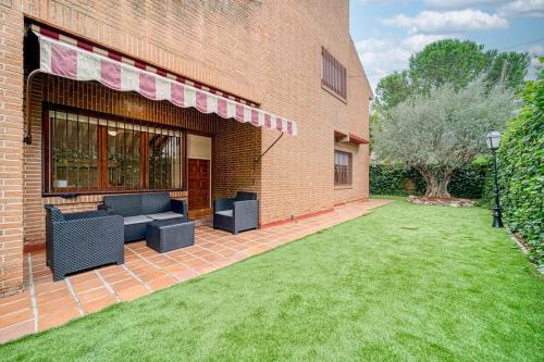 a brick building with a lawn in front of it at P CasaCafe Madrid Calle Carlos Dubois 3 in Madrid