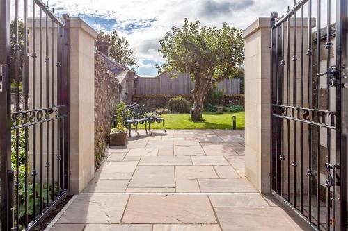 a gate to a garden with a table and chairs at The Rose and Thistle Alwinton in Morpeth