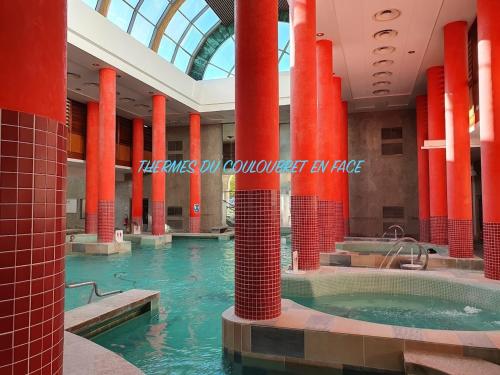 an indoor pool with red columns in a building at ∞ Hyper centre ∞ La marmotte ∞ petit T2 ∞ entrée24h/24 ∞ près ski/cure ≈AX-LES-THERMES≈ wifi ∞ in Ax-les-Thermes