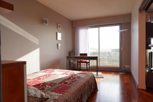 une chambre avec un lit, un bureau et une fenêtre dans l'établissement Rue Saint Saens - Paris 15, à Paris