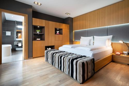 a bedroom with a large bed and a bathroom at INNSiDE by Meliá Prague Old Town in Prague