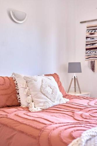 a bed with an orange blanket and pillows on it at Inlet Shack - 300 meters to the beach in Aireys Inlet