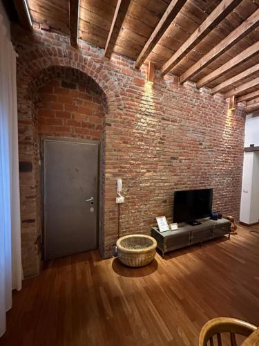 a living room with a brick wall and a door at Emme Loft I First Moon - Exclusive Design Apartment with balcony in Milan