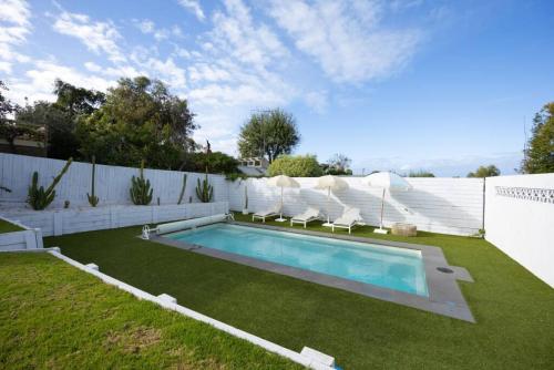 a backyard with a swimming pool and a fence at Warm Heated Pool All Year - Palm Springs in Torquay