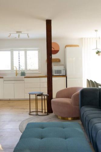a living room with a couch and a kitchen at Warm Heated Pool All Year - Palm Springs in Torquay