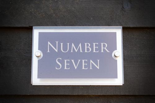a sign that says number seven on a wall at Bespoke 1 Bedroom Barn by Stansted Airport & Holiday Parking in London Stansted Airport