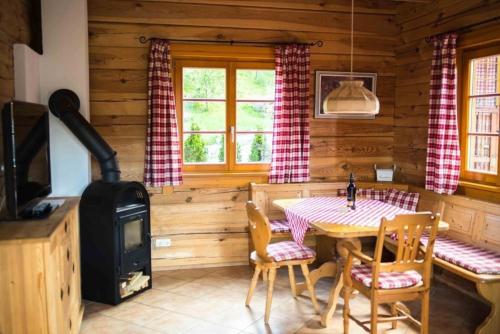 a dining room with a table and a stove at Charmantes Ferienhaus in Sankt Margarethen Im Lungau mit Kleinem Garten und Bergblick in Sankt Margarethen im Lungau