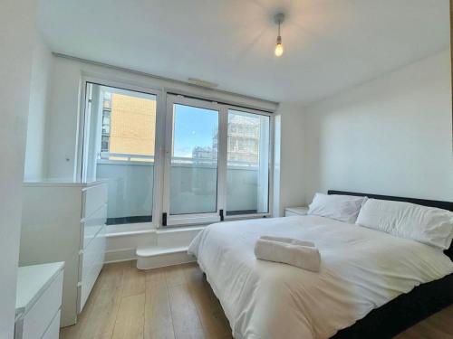 a white bedroom with a large bed and two windows at TTSA - 2 Bedroom Apartment-Croydon - Mayday Hospital in Croydon
