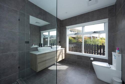 un bagno con un water, un lavandino e una finestra di Ocean View Cottage - Anglesea a Anglesea
