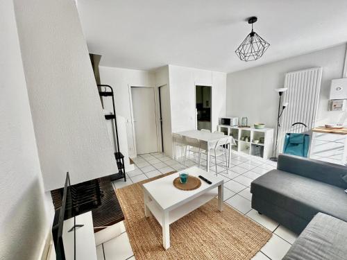 un salon avec un canapé et une table dans l'établissement La Casita, triplex avec jardin proche du centre, à Courseulles-sur-Mer