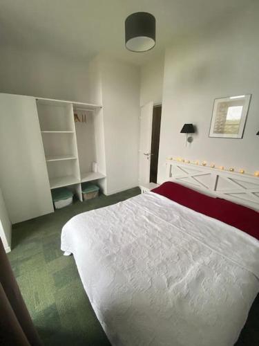 une chambre avec un grand lit blanc dans une pièce dans l'établissement Appt à Baden au château de Kergonano, à Mériadec