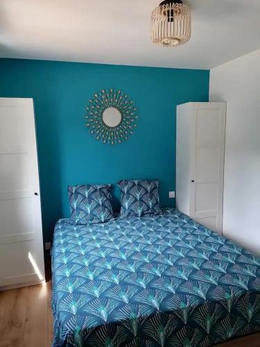 - une chambre bleue dotée d'un lit avec un mur bleu dans l'établissement Joli chalet contemporain, calme et verdure., à Martin-Chapon