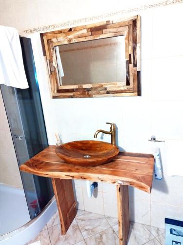 a bathroom with a wooden sink and a mirror at Cottage Piatra Craiului in Zărneşti