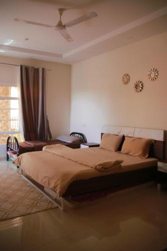 a bedroom with a large bed and a ceiling fan at Bidiya oasis in Al Raka