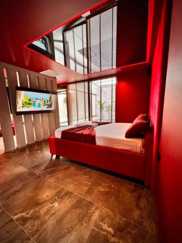 a bedroom with a bed with a red wall at Motel Villa Princi in Kosovo Polje