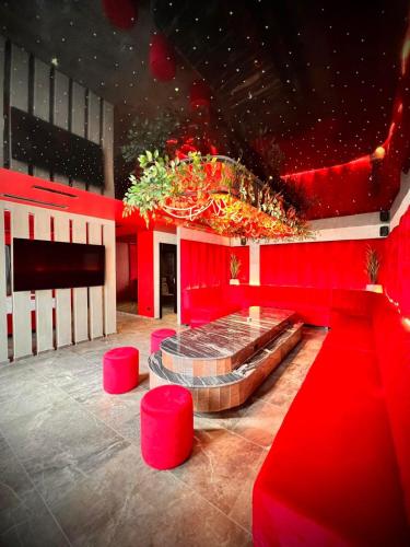 a red room with a stage and red stools at Motel Villa Princi in Kosovo Polje
