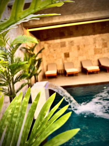a swimming pool with chairs and a fountain in a building at Motel Villa Princi in Kosovo Polje