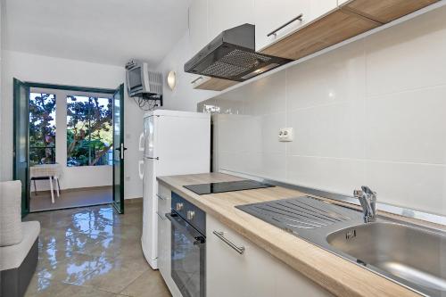 a kitchen with a sink and a refrigerator at Apartmani Nikola in Zastražišće