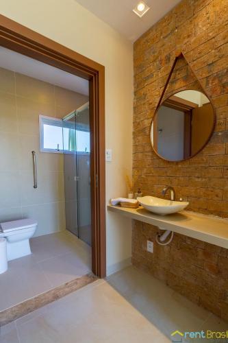 a bathroom with a sink and a toilet and a mirror at Reserva Sauípe - Casa 189 in Costa do Sauipe