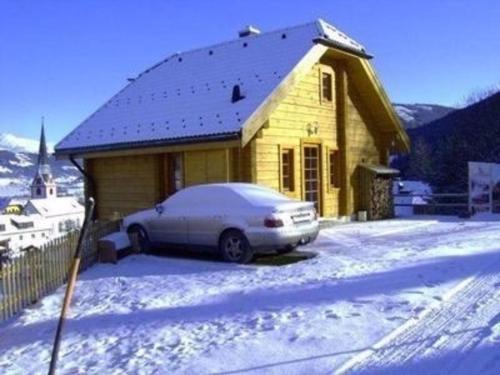 a car parked in front of a house in the snow at Komfortables Ferienhaus in Sankt Margarethen Im Lungau mit Eigener Sauna in Sankt Margarethen im Lungau