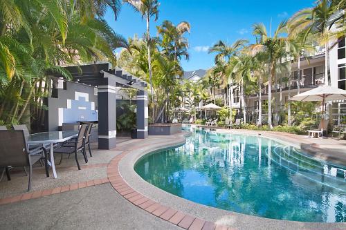 a pool at a resort with a table and chairs at Blue Waters Apartments in Gold Coast