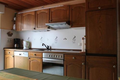Una cocina con gabinetes de madera y un horno de estufa. en Ferienhaus am Bach, en Oberdiebach
