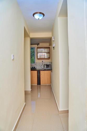a hallway with a kitchen with a sink and a stove at SHIMBA SPRINGS MBUYU. ( Malindi) in Malindi