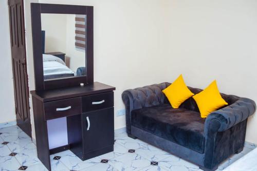 a living room with a couch and a mirror at Vitoria Apartment 2 in Gidan Nbora