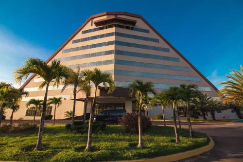 a building with palm trees in front of it at Eurobuilding Hotel & Suites Guayana in Puerto Ordaz