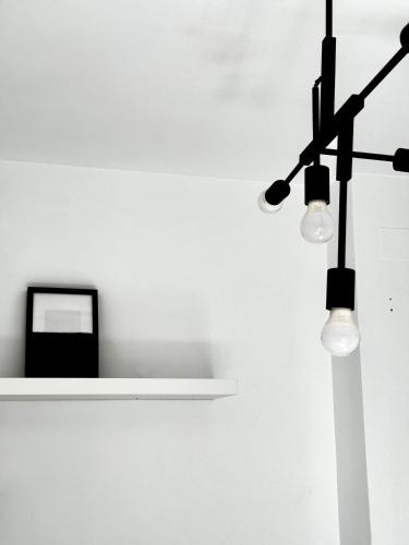 a light on a wall next to a shelf with a clock at Alcarria , Casa del Agua in Albalate de Zorita