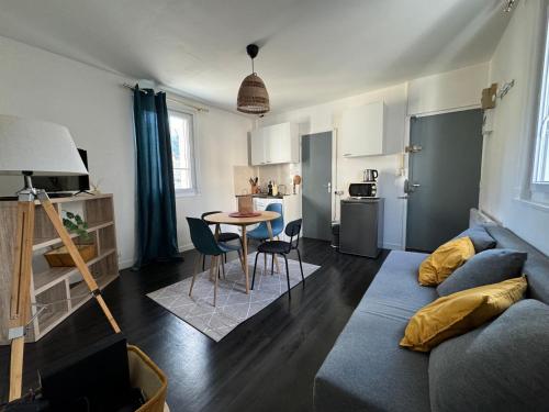 a living room with a couch and a table at Appartement Caen théâtre in Caen
