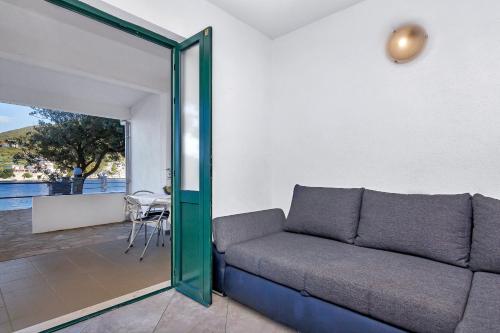 a living room with a couch and a patio at Apartmani Nikola in Zastražišće