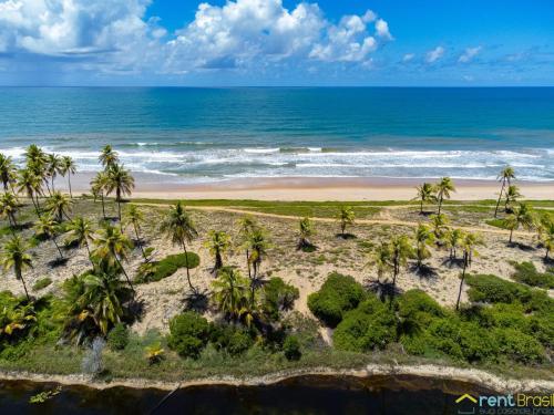 an aerial view of a beach with palm trees and the ocean at Reserva Sauípe - Casa 189 in Costa do Sauipe