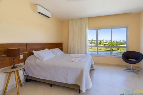 a bedroom with a bed and a large window at Reserva Sauípe - Casa 189 in Costa do Sauipe