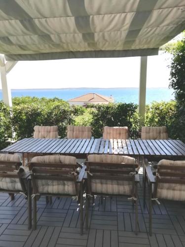 a table and chairs on a patio with the ocean in the background at Ferienhaus am Meer in Rtina