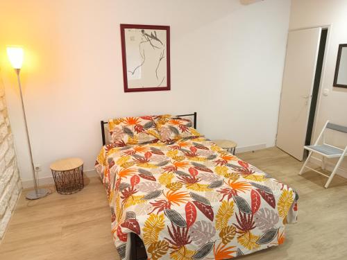 - une chambre avec un lit doté d'un couvre-lit coloré dans l'établissement Lumineux appartement climatisé, à Montpellier