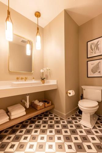 a bathroom with a sink and a toilet and a mirror at Sinclair Suites - Stylish Retro Boutique Hotel in West Dundee