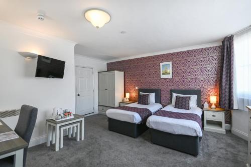 a hotel room with two beds and a tv at The Buttery in Oxford
